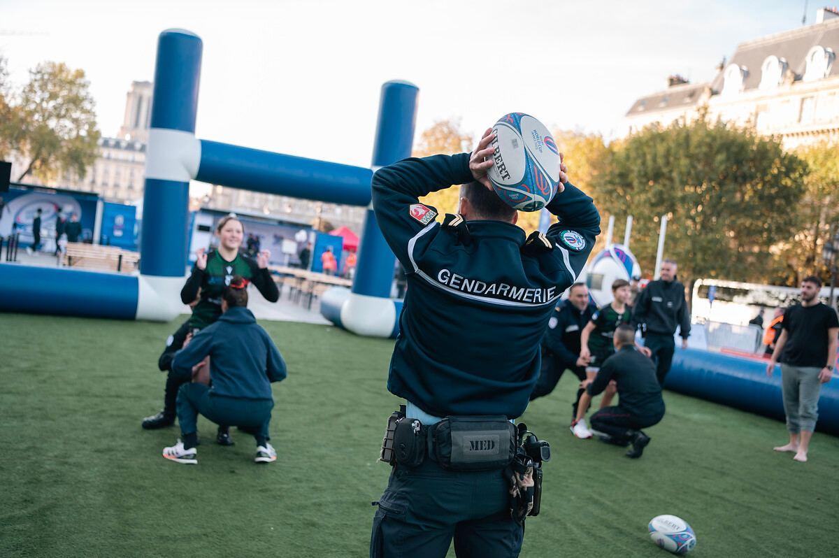 Un gendarme lance un ballon de rugby lors du Rugby Tour France à Paris.